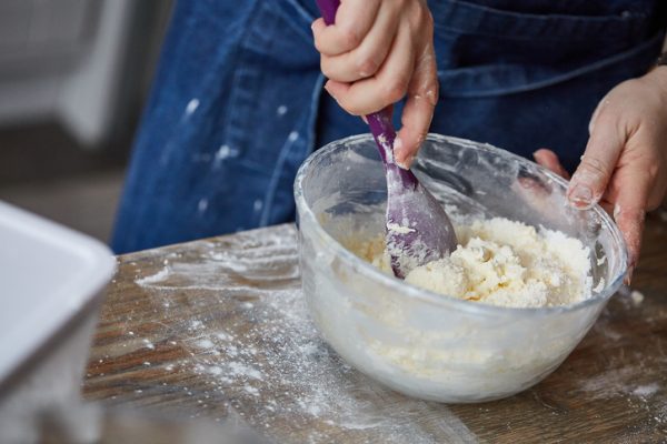 surinaamse bojo dessert: persoon mengt ingrediënten in een schaal