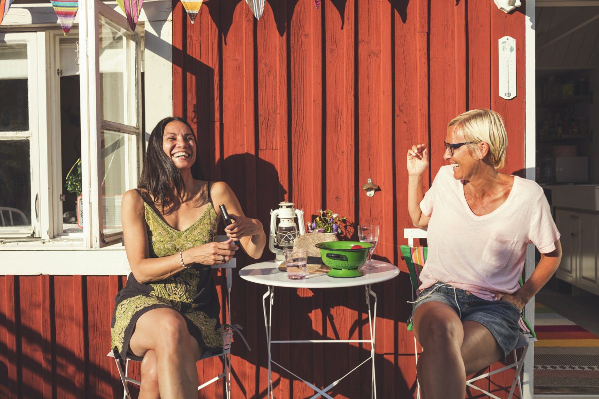 Cheerful Mature Female Friends Enjoying Summer In Back Yard On Sunny Day