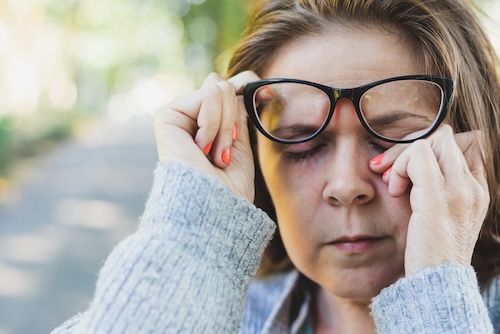 vrouw met ontstoken ooglid wrijft in oog