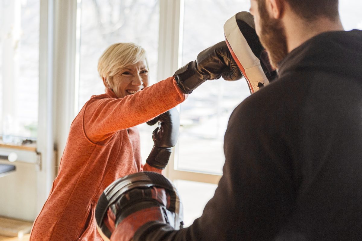 Senior Women Training With Instructor At Boxing Gym