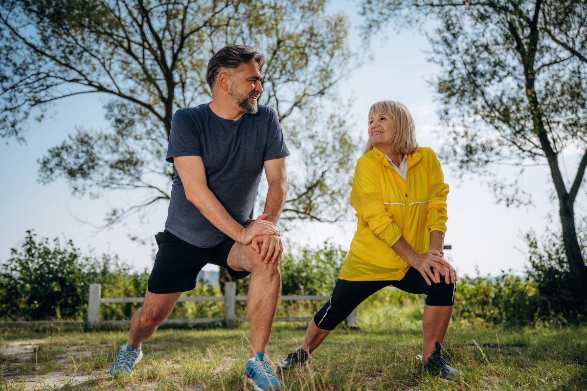 Lunges Exercise. Senior Couple Together Outdoors At Nature