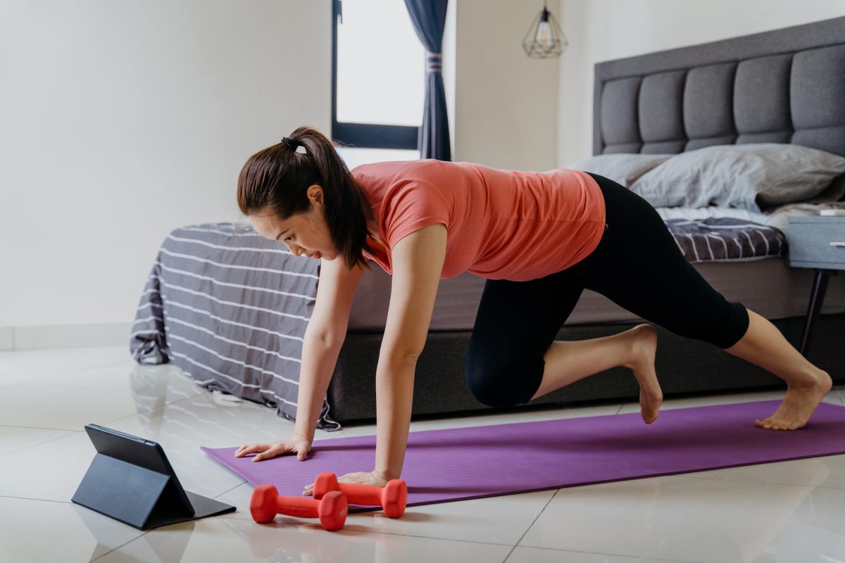 Young Asian Woman Doing Mountain Climber Exercise In Bedroom