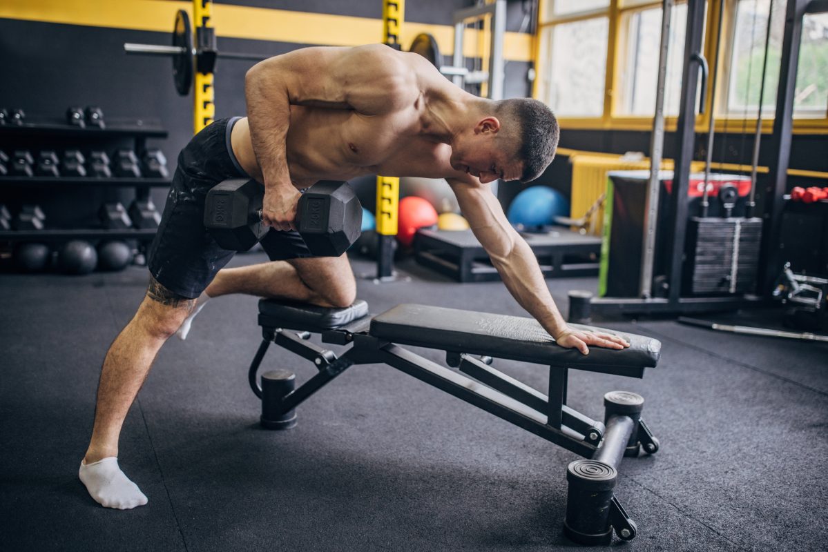 Man Focusing On Form During Single Arm Dumbbell Row. Rugspieren