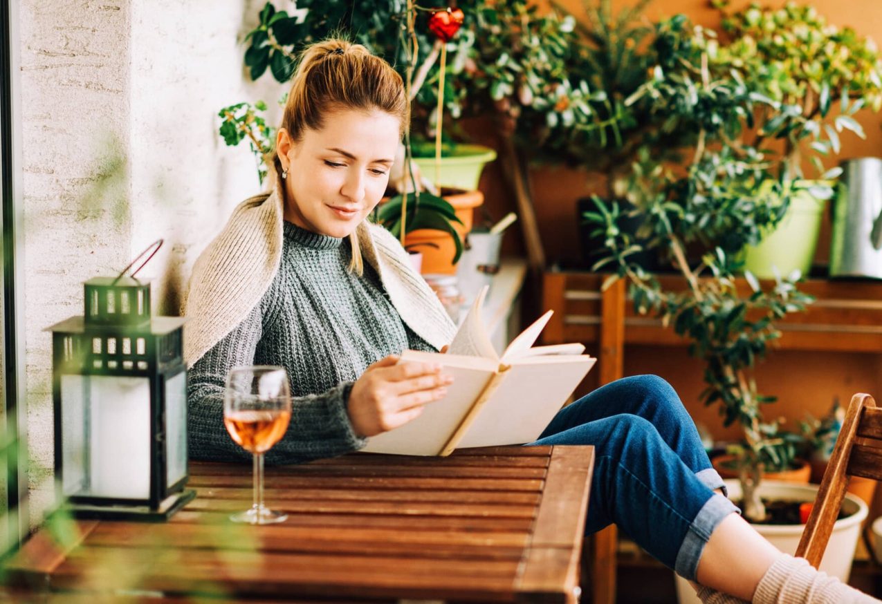 vrouw leest boek in tuin: tuin als tweede woonkamer