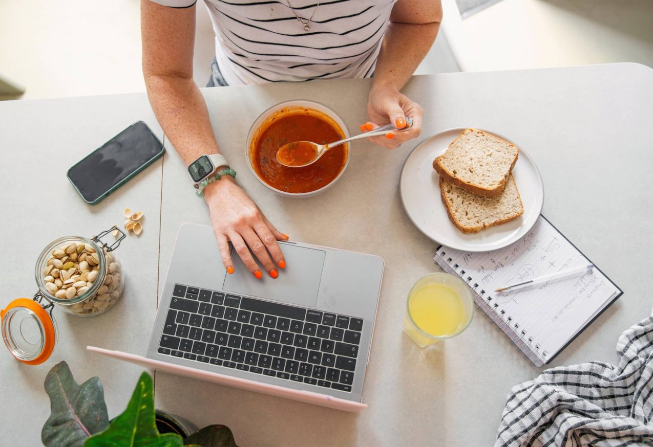 Gezonde Leefstijl op Werk: vrouw werkt op laptop en eet soep
