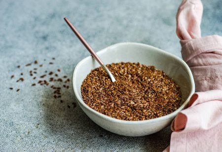 Lijnzaad Gezond: Schaal met lijnzaadjes op een tafel naast een roze servet