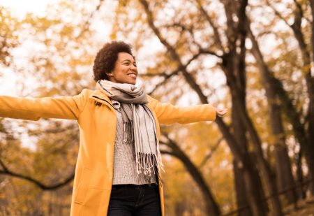 Wandelhotel: Vrolijke midden volwassen vrouw genietend van een mooie herfstdag in de natuur