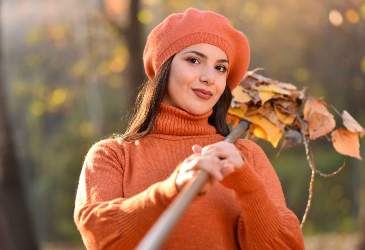 Winterklaar: vrouw harkt herfstbladeren