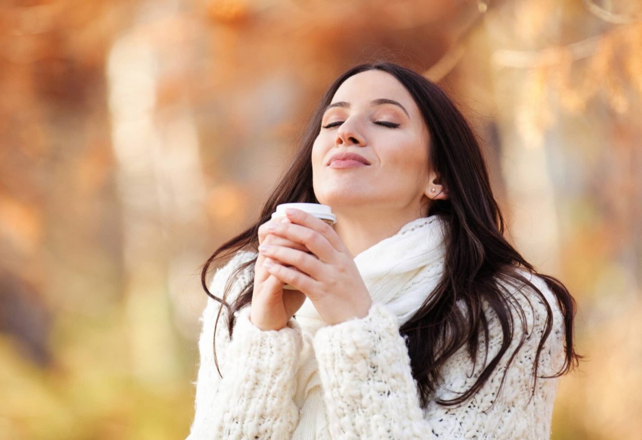 Cosy Truien: Mooie jonge vrouw genietend van de herfst in het park