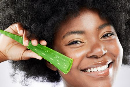 Studio Shot Of An Attractive Young Woman Posing With An Aloe Plant Plant Against A Grey Background